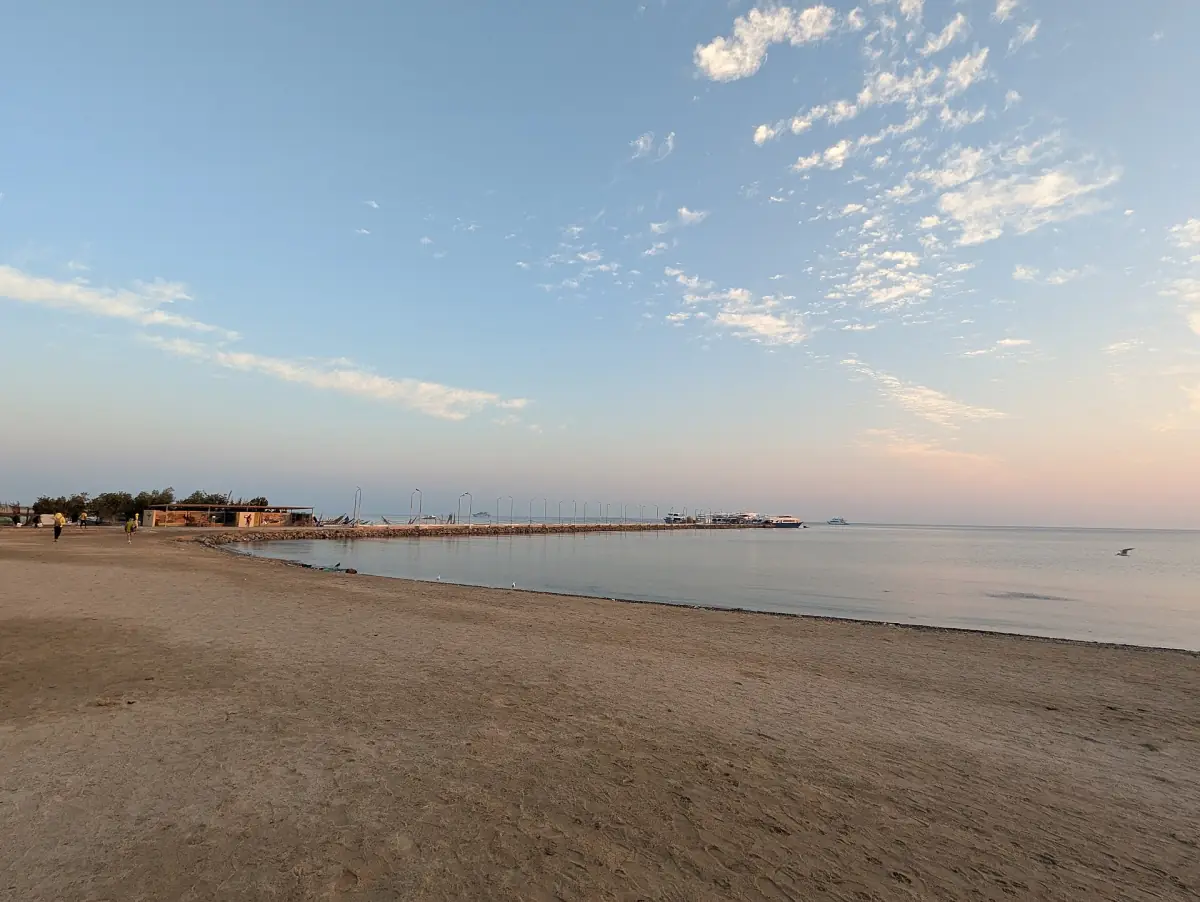 Quiet sandy beach in soft morning light with calm water