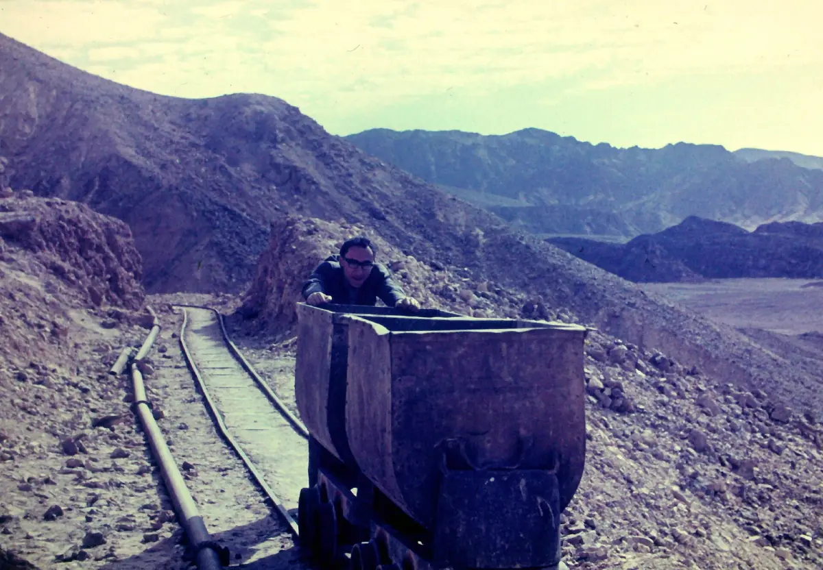 An old mine cart on rails in the mountains