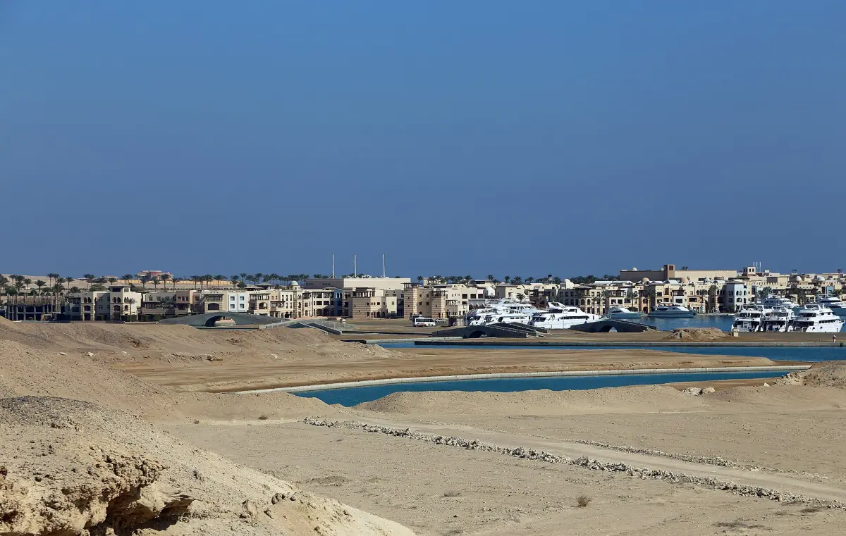 View over a marina with moored boats and low buildings