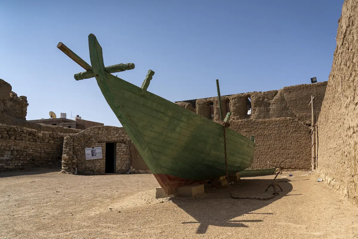 Courtyard of an old fort with a wooden boat on display