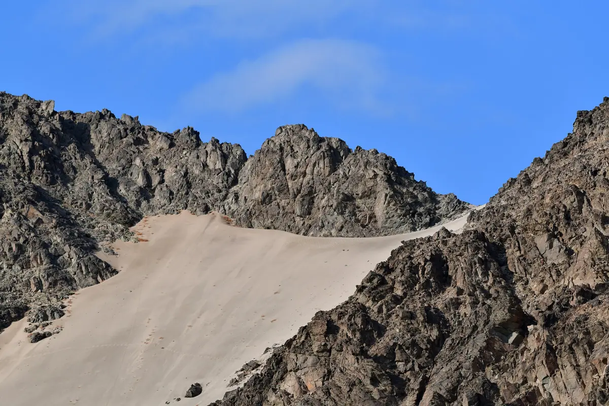 Rugged desert mountains with a pale sand slope